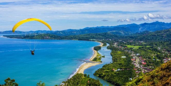 BERAKSI—Seorang atlet paralayang tengah unjuk gigi beraksi dari atas Bukit Langkisau Pessel. Rencananya, Festival Paralayang Pesona Langkisau akan digelar di Bukit Langkisau Painan, 12  hingga 13 Juni mendatang.