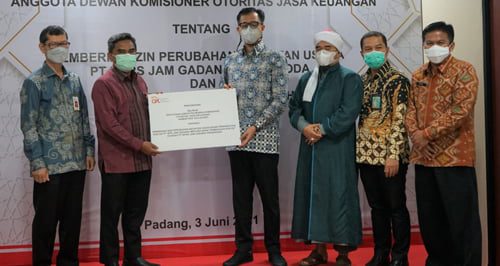 SERAHKAN SK—Kepala OJK Sumbar Misran Pasaribu  menyerahkan salinan Keputusan Anggota (SK) Dewan Komisioner Otoritas Jasa Keuangan konversi BPD menjadi BPRS kepada Wali Kota Bukittinggi Erman Safar.