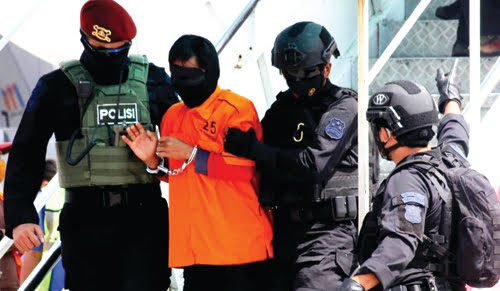 Densus 88 Bergerak ke Tasikmalaya, Ada yang Ditangkap Usai Salat Jumat 1 PENGAMANAN—Terlihat terduga teroris yang ditangkap turun dari tangga pesawat dengan pengamanan ketat Tim Densus 88 Mabes Polri
