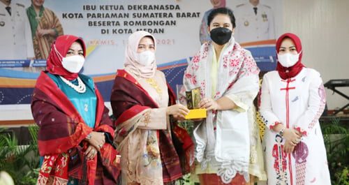 SERAHKAN CENDERA MATA—Istri Wali Kota Medan Kahiyang Ayu dan istri Wako Pariaman Lucy Genius Umar  saling tukar cendera mata.