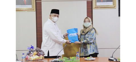 TERIMA CENDERA MATA— Wali Kota Solok Zul Elfian saat menerima cendera mata dari pimpinan cabang PT PNM saat berkunjung ke Kota Solok.