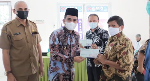 Ramadhani secara simbolis menyerahkan kartu JKN kepada masyarakat Copy