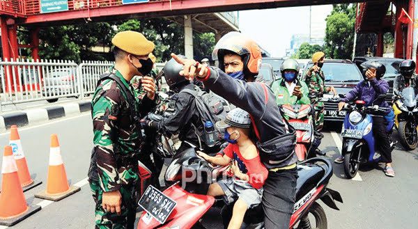 Jokowi Memperpanjang PPKM, Muhammadiyah: Salurkan BLT Secepatnya 1 PERIKSA— Aparat TNI memeriksa kelengkapan dokumen pengguna jalan di Pos Penyekatan PPKM Darurat Underpass Mampang, Jakarta Selatan, pekan lalu.