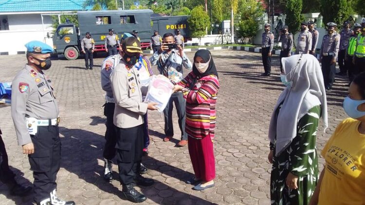 SERAHKAN BANTUAN— Kapolres Pessel AKBP. Sri Wibowo, S.IK, M.H menyerahkan simbolis bansos Polri - TNI pada warga.