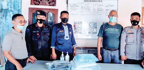 KELENGKAPAN APD— Bripka Hendri Syarif, Lurah, RT dan tokoh masyarakat memperlihatkan kelangkapan APD sebelum pelaksanaan vaksinasi massal, kemarin.