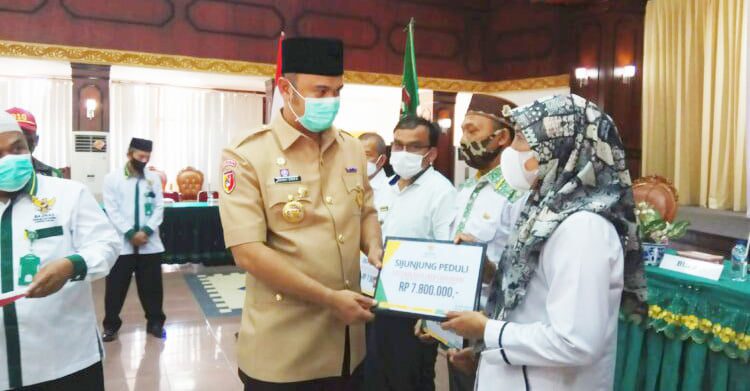 SERAHKAN DANA ZAKAT—Bupati Sijunjung, Benny Dwifa menyerahkan zakat kepada mustahiq. Kegiatan ini merupakan tindak lanjut program Sijunjung berzakat yang telah dicanangkan.