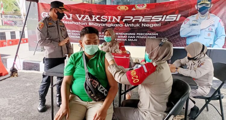 DIVAKSIN—Petugas kesehatan Biddokkes Polda Sumbar memberikan suntikan vaksinasi Covid-19 gratis bagi warga yang datang ke Gerai Vaksin Presisi.