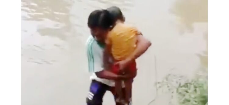 EVAKUASI— Salah seorang  warga saat mengevakuasi jasad bocah perempuan yang ditemukan tewas hanyut di Batang Lembang.