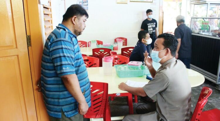 LANGGAR ATURAN— Petugas Satpol PP Kota Padang mendatangi pemilik rumah makan di kawasan Dobi, kemarin, karena sudah melanggar aturan selama PPKM Darurat.