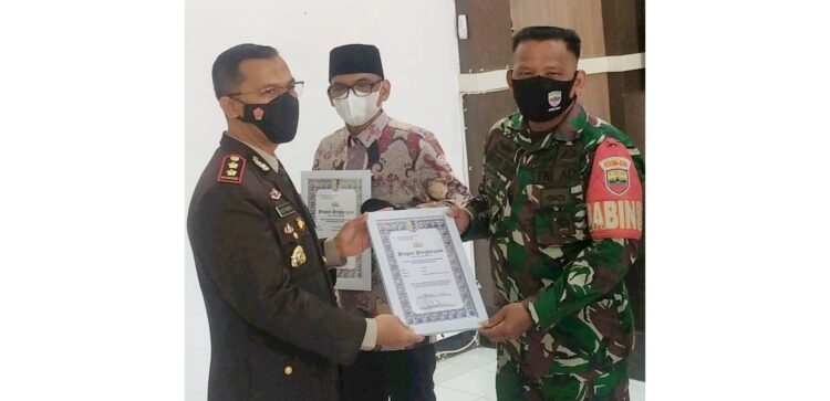 PENGHARGAAN—Sersan Kepala Junaidi, Anggota Satgas yang ikut serta dalam rangkaian kegiatan TMMD/N ke 111 tahun 2021 Kodim 0306/50 Kota menerima langsung penghargaan dari Kapolres Kota Payakumbuh.