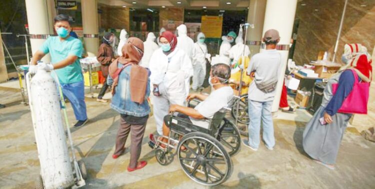 COVID— Sejumlah tenaga kesehatan menangani pasien Covid-19 yang baru tiba di IGD.