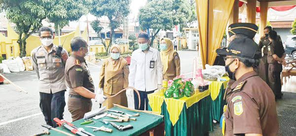 MUSNAHKAN BB— Kajari Padang Ranu Subroto didampingi para kasi, memperlihatkan barang bukti berupa senjata tajam berbentuk samurai saat pemusnahan BB kasus kriminalitas di Kota Padang.