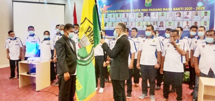 TERIMA—Ketua Pengcab PBSI Padang periode 2021- 2025 Mukhlis SE menerima petaka PBSI dari Ketua Pengprov PBSI Sumabr Alfiadi saat pelantikan  di salah satu hotel di Kota Padang.