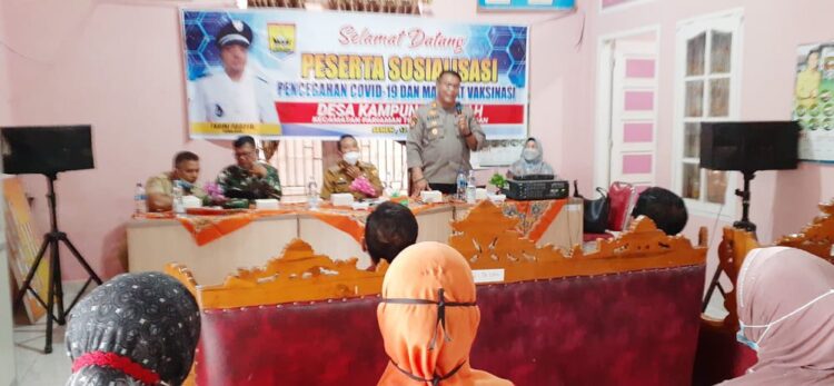EDUKASI—Kapolsek Pariaman AKP Edi Karan P berikan materi sosialisasi manfaat vaksin di Desa Kampung Tangah, Kecamatan Pariaman Timur, Kota Pariaman.