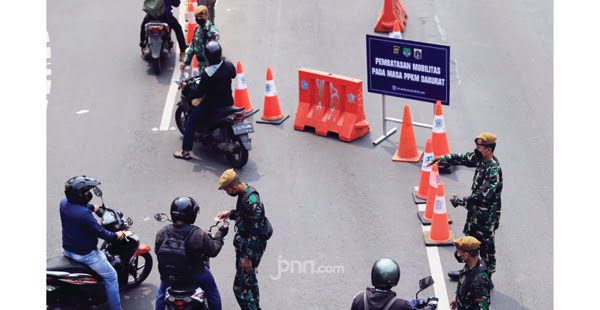 PENYEKATAN—Terlihat beberapa orang tim gabungan sedang menjaga batas penyekatan masa Pemberlakukan Pembatasan Kegiatan Masyarakat (PPKM) Darurat.