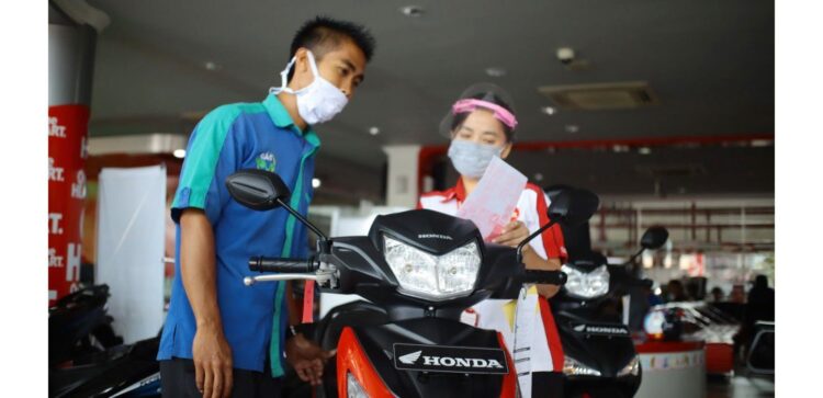 LAYANI KONSUMEN-Sales Marketing Menara Agung tengah melayani konsumen saat pembelian Honda Supra GTR 150.