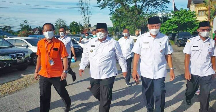 TINJAU— Gubernur H Mahyeldi didampingi Bupati Padangpariaman Suhatri Bur, meninjau  lokasi dan menyerahkan bantuan program bansos tunai dan beras KKM tahun 2021 di Kantor Pos Indonesia Kecamatan 2x11 Kayu Tanam, Kabupaten Padangpariaman.