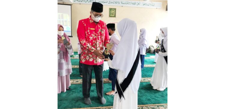 PROSESI WISUDA—Kepala MTs Lubuk Kilangan Zulmaidi mewisuda dan memasang selempang 15 siswa/siswi penghafal 1 juz Al Quran pada 19 Juni 2021. Pada tahun ini, lulusan MTs Luki 93 persen diterima di sekolah negeri.