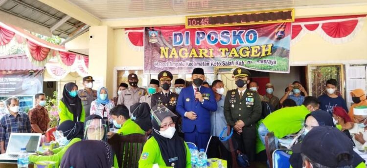 Peringatan Hari Bhayangkara ke-75, Ribuan Masyarakat Dharmasraya Ikuti Vaksinasi 1 VAKSINASI— Bupati Sutan Riska Tuanku Kerajaan bercengkrama dengan masyarakat penerima vaksin.