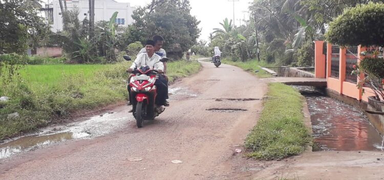 Sudah Lama Rusak, Penuh Lubang, Jalan Menuju SMA 16 tak Kunjung Diperbaiki 1 jalan rusak— Pengendara motor melintasi ruas jalan menuju SMA Negeri 16 dan pekuburan Bukit Napa Padang yang kondisinya sudah banyak berlubang. Warga pun berharap jalan ini bisa segera diperbaiki.
