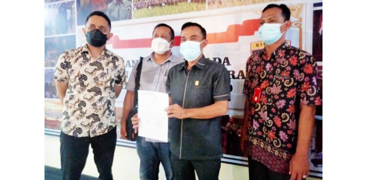 MELAPOR— Ketua DPRD Kabupaten Solok Dodi Hendra memperlihatkan bukti laporan 
polisi usai melaporkan Bupati Solok Epyardi Asda terkait dugaan pencemaran nama baik. 