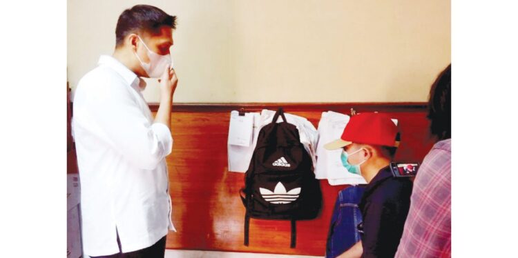 INTEROGASI—Polisi menginterogasi HN bertopi merah sebagai mucikari yang menjual pelajar SMP kepada lelaki gay.