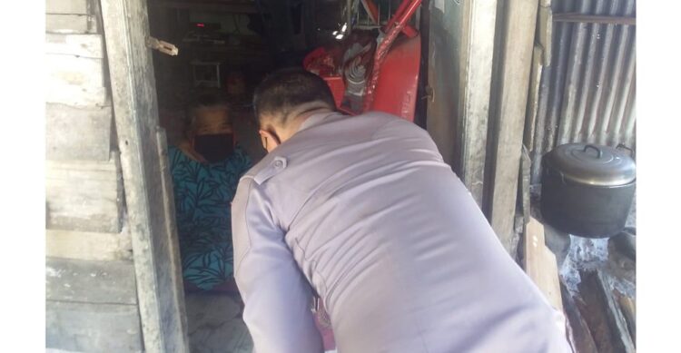 Rosna (76) Alami Lumpuh, warga Pasie Muaro, Kenagarian Painan Selatan, “Terimo Kasih Pak Polisi Bantuannyo” 1 TERIMA BANTUAN— Rosna (76), warga tidak mampu, saat menerima bansos PPKM Polri - TNI, yang diserahkan Kasat Binmas Polres Pessel AKP. Gusfriandi, SH.