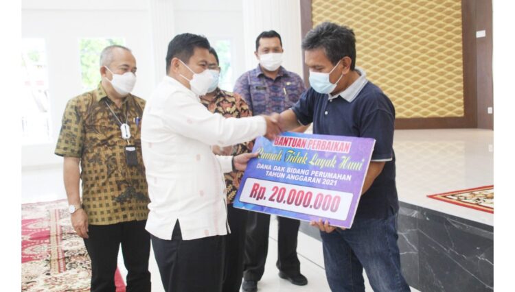 SERAHKAN--Pj Sekdako Bukittinggi Rismal Hadi menyerahkan bantuan sosial RTLH untuk masyarakat berpenghasilan rendah (MBR) di Pendopo Rumah Dinas Walikota.