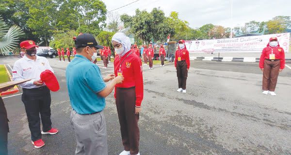 LATIHAN— Ketua Purna Paskibraka Indonesia (PPI) Kota Bukittinggi, Nenta Oktavia menyematkan tanda peserta latihan calon Paskibraka.