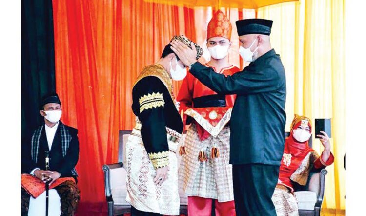 PASANG SALUAK— Prosesi pemasangan saluak oleh gubernur Sumbar Mahyeldi kepada Danlantamal II Laksma TNI Hargianto SE. MM, MSI (Han) Datuak Bagindo Malano Nan Hitam.