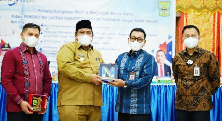 Bank Nagari dan Pemkab Padangpariaman Kerja Sama Digitalisasi Ekonomi 1 Penyerahan cendera mata usai penandatangan kerja sama antara Direktur Utama Bank Nagari Muhamad Irsyad dan Bupati Padangpariaman, Suhatri Bur. Dihadiri juga Kepala OJK Sumbar Yusri dan Kepala BI Wahyu Purnama.