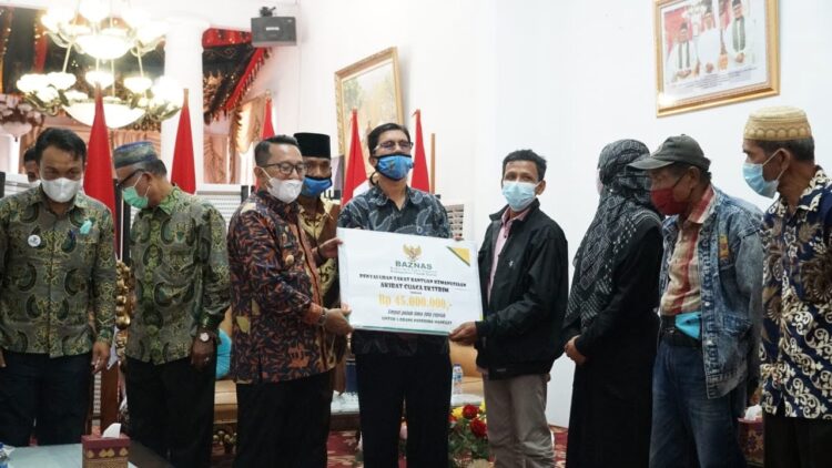 Baznas Tanah Datar Salurkan Bantuan, Enam Rumah Rusak Dampak Cuaca Ekstrem 1 BANTUAN—Bupati Eka Putra serahkan bantuan pada korban cuaca ekstrem.