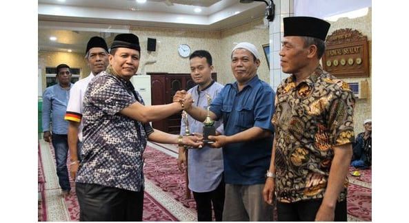 SERAHKAN—Ketua DPD LPM Kota Padang Irwan Basir Dt Rj Alam menyerahkan sumbangan kepada pengurus Masjid Nurul Isla Kampuang Jawo.