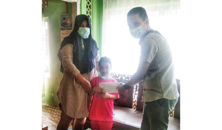 SERAHKAN DONASI— Komunitas Pensil Ajaib (Pensila) menyalurkan donasi untuk memenuhi biaya pendidikan bagi siswa kurang mampu yang memiliki semangat belajar tinggi. Pada aksi perdana itu, Aura Fazila Ramadhani (7) pelajar kelas 2 SDN 41 Sangkir menjadi sasaran penerima donasi.