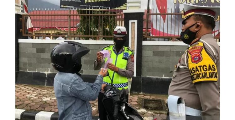 BAGIKAN MASKER— Anggota Satlantas Polres Pasaman membagikan masker kepada pengendara.