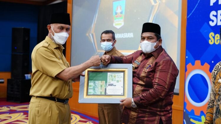 PENGHARGAAN—Bupati Padangapriaman Suhatri Bur  terima penghargaan dari Gubernur Mahyledi.