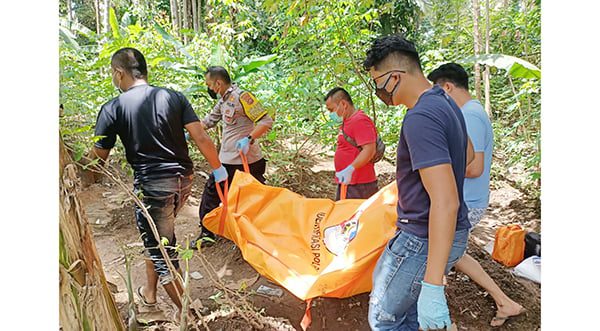EVAKUASI— Polisi dibantu masyarakat jorong Simpang, nagari Kotobaru, Kabupaten Solok, mengevakuasi jenazah seorang petani yang ditemukan meninggal di sebuah pondok kebun kelapa.