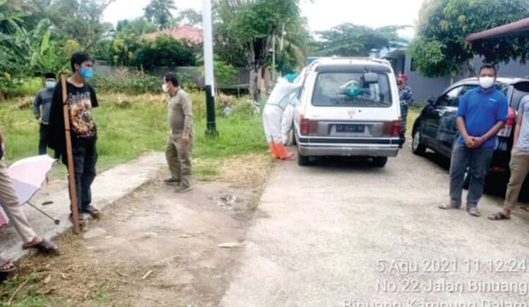 PEMAKAMAN— Petugas medis membawa jenazah pasien terpapar Covid-19 untuk dimakamnkan di perkuburan kaum di Pauh, Kamis (5/8).