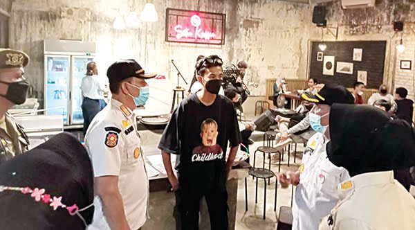 MELANGGAR ATURAN— Personel Satpol PP Kota Padang menyisiri sejumlah tempat usaha yang masih tidak mematuhi aturan prokes di tengah pandemi Covid-19, Kamis (9/9) malam. Dua pemilik kafe dan restoran terpaksa dibawa ke Mako Satpol PP karena melanggar aturan.