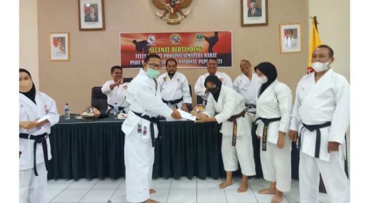 SERAHKAN--Ketua Lemkari Sumbar Yozarwardi menyerahkan uang saku kepada salah seorang karateka dan pelatih  berangkat ke PON XX Papua.