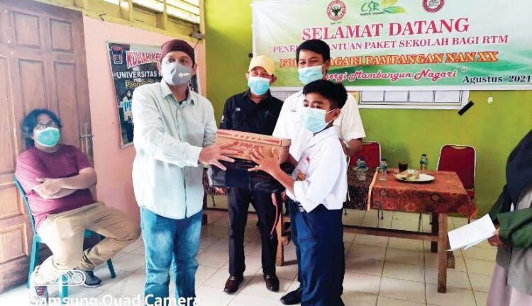 KETUA Forum Nagari Pampangan Nan XX Edison, menyerahkan bantuan paket pendidikan kepada pelajar SMP yang berasal dari rumah tangga miskin, disaksikan Kepala Unit CSR PT Semen Padang Rinold Thamrin, di gedung Balai Pertemuan Pampangan.