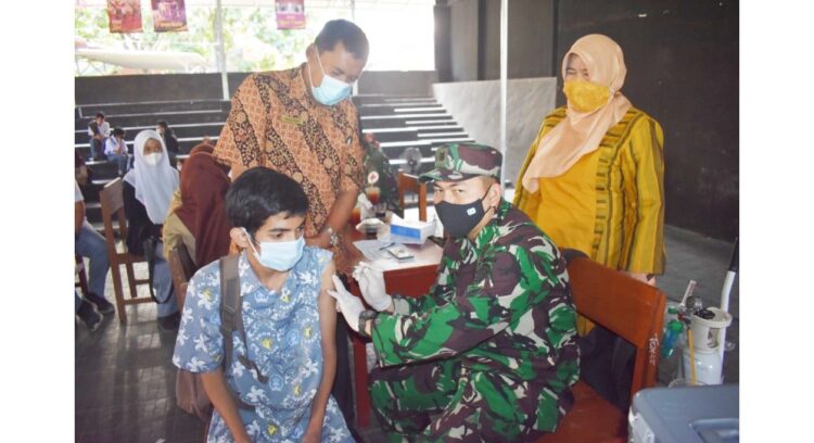 VAKSINASI PELAJAR— Tim Tenaga Kesehatan Tonkes  Yonif 133 Yudha Sakti sedang melakukan vaksinasi Covid-19 kepada siswa dan disaksikan Kepala SMKN 4 Padang Taharuddin dan Kepala SMKN 7 Herawaty.