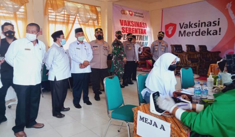 VAKSINASI PELAJAR— Salah seorang siswa Madrasah sedang menjalani vaksinasi dan disaksikan sejumlah pejabat daerah Tanahdatar, Selasa (7/9).