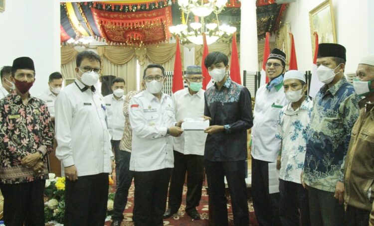 SERAHKAN BANTUAN BEASISWA—Bupati Eka Putra menyerahkan bantuan bagi putra putri Tanahdatar yang kuliah di luar negeri.