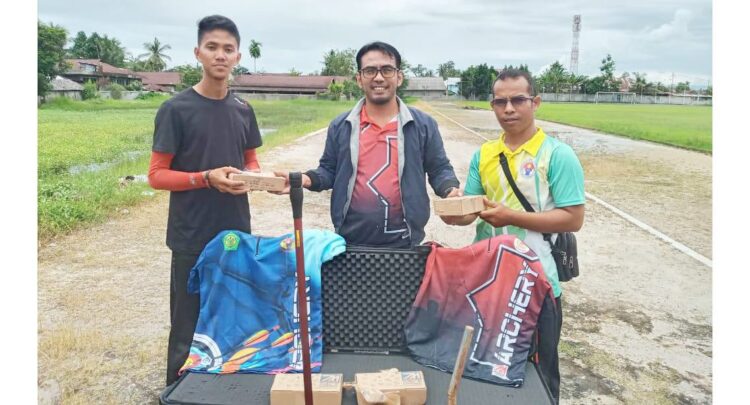 BANTUAN ALAT PANAHAN—   Sekum Perpani Sumbar Roni Parma menyerahkan alat tanding panah kepada Ego Izra Rahman, Minggu (19/9) di Kampu II FIK UNP.