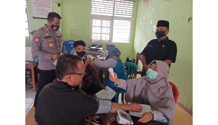 SAKSIKAN—Kapolsek Harau bersama Kepala SMPN 1 Harau menyaksikan pelaksanaan vaksinasi bagi siswa dan warga sekitar sekolah.