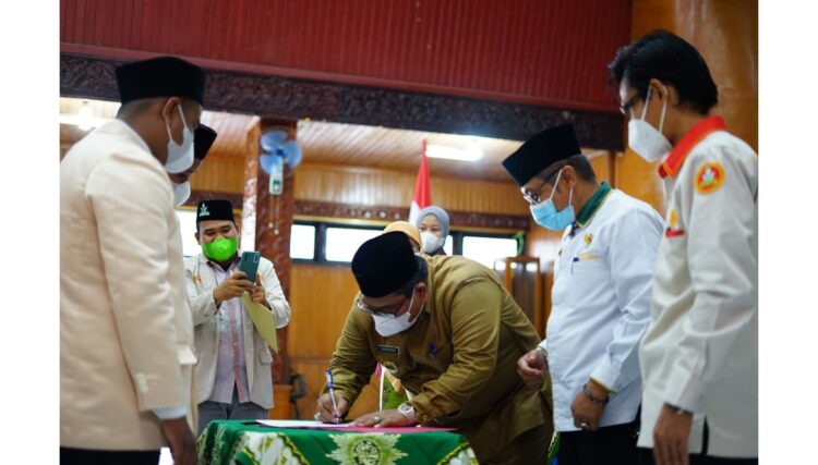 LANTIK—Bupati Padangpariaman, Suhatri Bur, SE usai melantik pimpinan daerah Pemuda Muhammadiyah Padangpariaman periode 2018 - 2022 menandatangani berkas pelantikan.