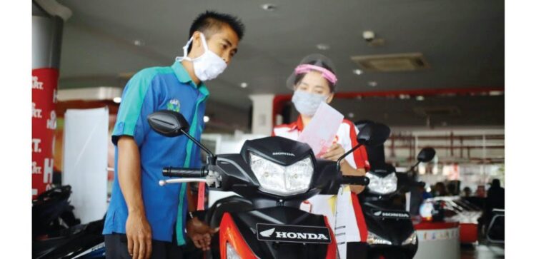 LAYANI KONSUMEN-Sales Marketing Menara Agung tengah melayani konsumen saat pembelian Honda Supra GTR 150.