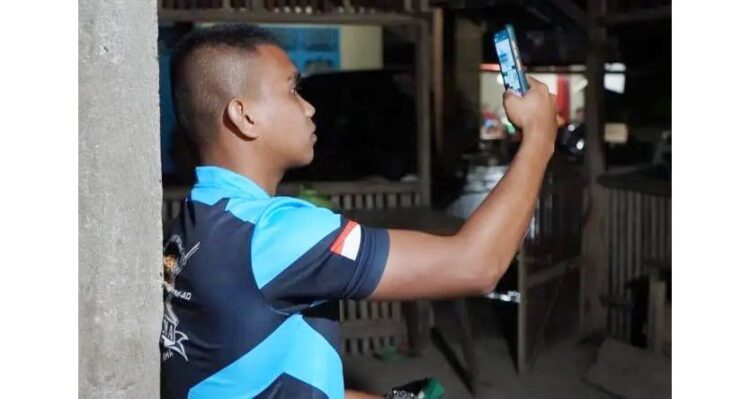 Rindu Keluarga saat Bertugas, Satgas TMMD ke-112 Agam Manfaatkan VC untuk Komunikasi 1 LEPAS RINDU—Anggota Satgas TMMD ke-112, Serda Erfan melepas rindu bertemu keluarga di rumah, dengan VC menggunakan aplikasi pada telepon selulernya, Minggu (26/9).