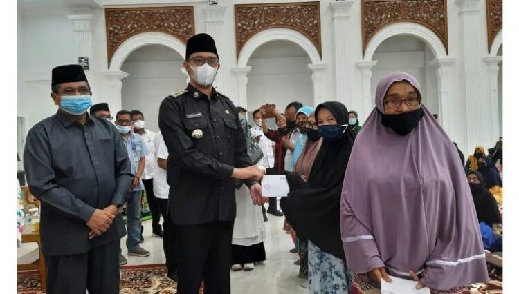 SERAHKAN DANA ZAKAT— Wali Kota Bukittinggi Erman Safar bersama Ketua Baznas menyerahlan Zakat untuk mustahik yang terdampak kebijakan PPKM.